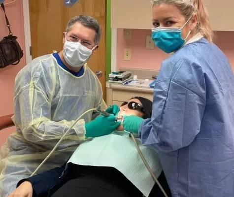 Dr. Russo and an RNS Dental assistant caring for a patient